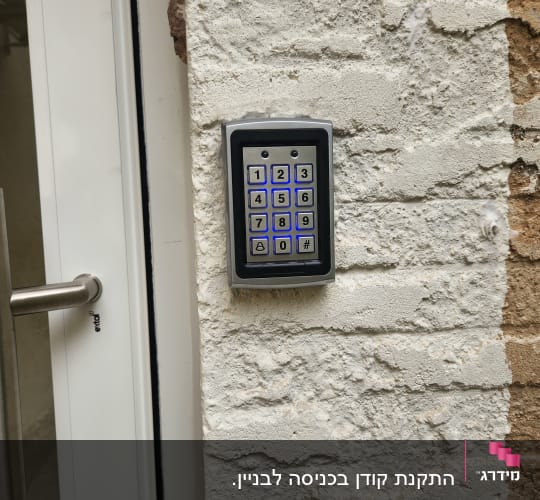 לוח מקשים של אינטרקום על קיר לבנים